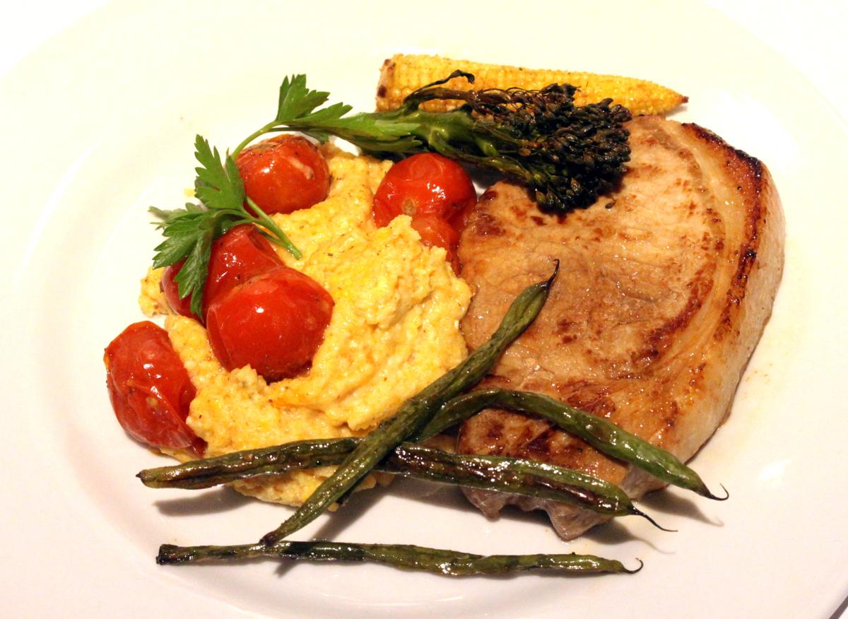 Rezeptbild: Tessiner Vollkorn Polenta mit gerösteten Kirschtomaten, Schweinekotelett und geröstetem Grünzuegs